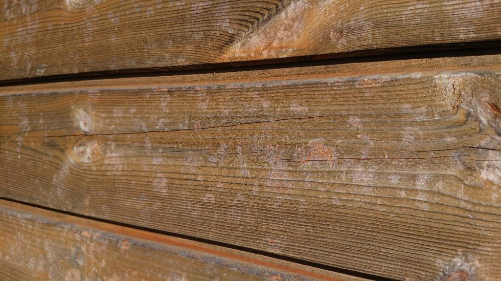 gros plan d'un bardage abimé par des impacts de grêle