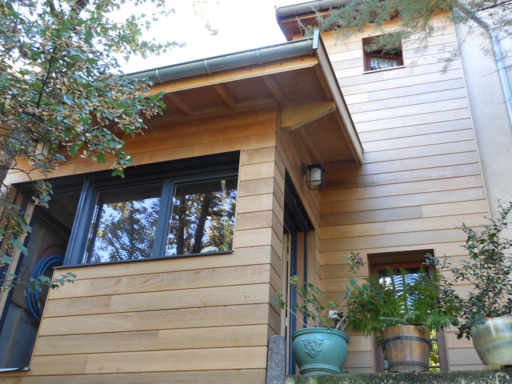 façade d'une maison avec un bardage en bois Red Cedar protégé avec un produit anti-UV