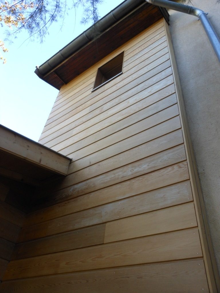 vue en contre-plongée d'un bardage en bois Red Cedar protégé avec un produit anti-UV